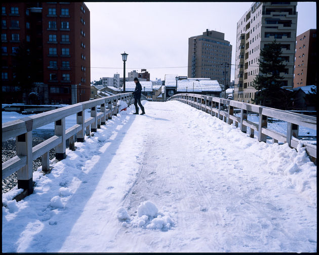 橋のたもとに積もった雪を、橋の上から浅野川へ捨てる